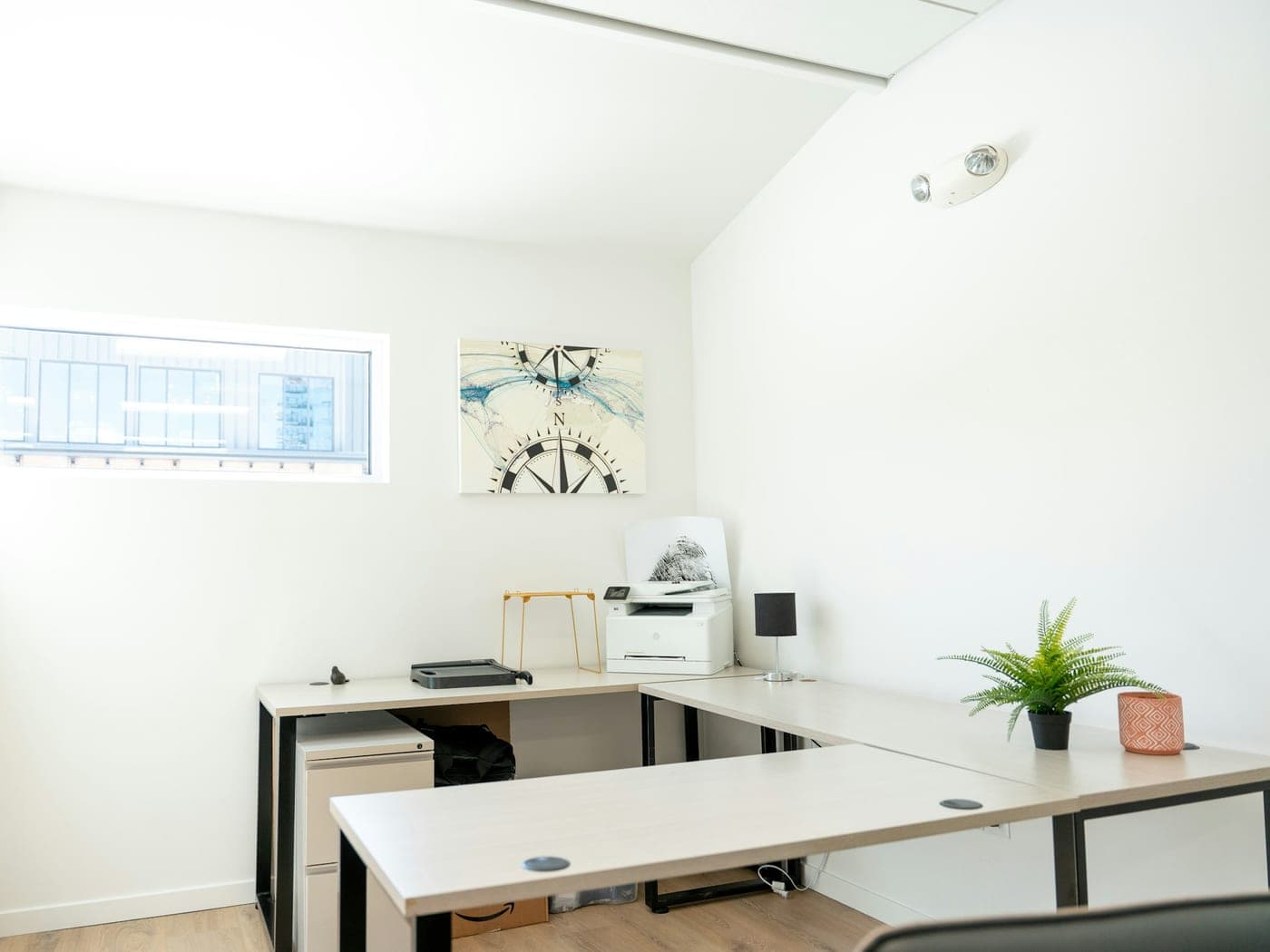 Bureau ordonné avec imprimante et plante, lumière naturelle