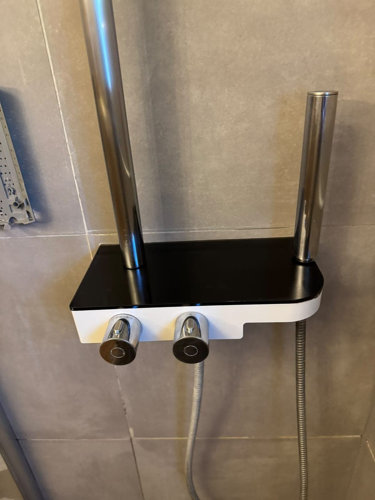 Colonne de douche chromée et sa tablette en verre noir, propres